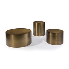 three brass colored stools on a white background