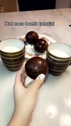 a person is holding some chocolates in front of their bowls on the counter top