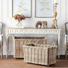 two wicker baskets sitting on top of a table next to a vase with flowers