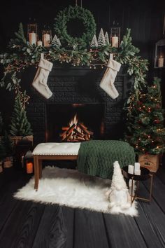 a fireplace decorated for christmas with stockings and candles