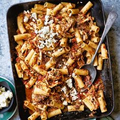 pasta with meat and feta cheese in a casserole dish on a table