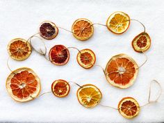 oranges cut in half sitting on top of a white cloth covered table with string