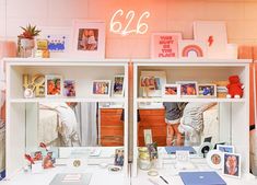 a white desk topped with lots of shelves filled with books and pictures on top of it