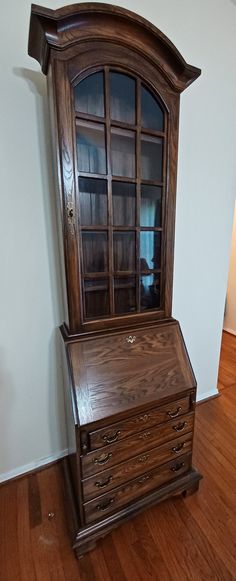 an old wooden dresser with glass doors and drawers