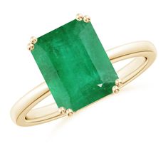 a gold ring with an emerald stone in the center and two smaller bands around it