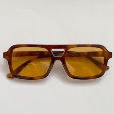 This vintage-inspired aviator is made from brown tort shell acetate and paired with a tan / orange coloured lens. This style is unisex. Dimensions:  Temple length: 14.5cm Lens width: 5.3cm Height: 4.1cm High Quality with UV protection.  Sunglasses are carefully packaged in bubble wrap to ensure they arrive to you in perfect condition 99p UK Shipping We ship using Royal Mail 2nd class and dispatch the same working day if ordered before 2pm. There is also an option at checkout to upgrade your ship Sunglasses Orange Lens, Brown Lens Sunglasses, Brown Aviator Sunglasses With Anti-reflective Coating, Brown Aviator Sunglasses With Anti-reflective Detail, Brown Aviator Sunglasses With Anti-reflective Square Frame, Modern Brown Aviator Sunglasses With Square Frame, Brown Square Frame Aviator Sunglasses With Anti-reflective Coating, Brown Square Frame Aviator Sunglasses With Uva Protection, Brown Square Frame Anti-reflective Aviator Sunglasses