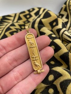 18k gold Egyptian pendant Ornate bale  Stamped  Features Variety of Hieroglyphics  Pretty cool and Unique 2 inches long 3.8 grams Carved Yellow Gold Amulet Jewelry, Symbolic Carved Gold Jewelry, Gold Rectangular Pendant With Etched Details, Gold Etched Rectangular Pendant Jewelry, Ancient Etched Gold Jewelry, Egyptian Pendant, Egyptian Hieroglyphics, Pretty Cool, Pendant Necklaces