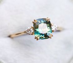 an engagement ring with a green and white diamond