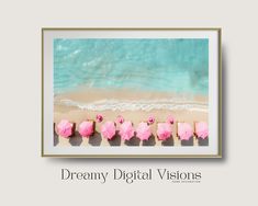 a group of pink elephants standing on top of a sandy beach next to the ocean