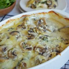 a casserole dish filled with cheese and mushrooms