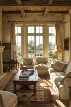 a living room with couches, chairs and a coffee table in front of two windows