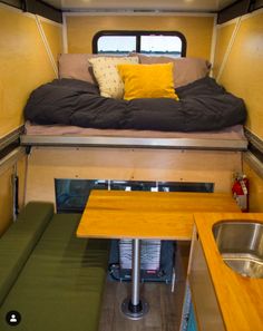 the interior of a camper with a bed and sink