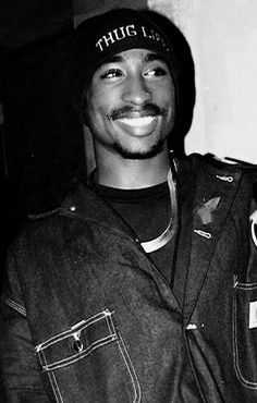 a black and white photo of a man wearing a hat with the word thu on it