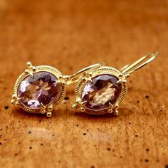 Renaissance jewelry is splendidly reborn. Our faceted amethyst ensemble belongs at a ball, or at least at a local disco. 24k gold over sterling silver granulated settings augment the brilliant sparkle of the faceted stones. European backs. Size: 1 Inch. Luxury Gold Amethyst Earrings, Exquisite Gold Earrings With Gemstone Accents, Faceted Yellow Gold Oval Earrings, Formal Gold Earrings With Gemstone Accents, Yellow Gold Faceted Oval Earrings, Yellow Gold Amethyst Earrings Hallmarked, Heirloom Faceted Gold Jewelry, Gold Amethyst Jewelry For Anniversary, Gold Earrings With Gemstone Accents