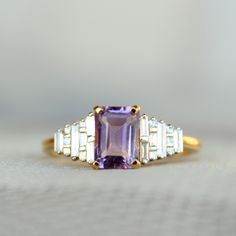 "1.08 Ct emerald cut natural Amethyst gemstone, with baguette and princess cut natural diamonds, this art deco inspired ring is all the rage! It makes for a gorgeous engagement ring and a family heirloom.. :) A perfect piece of birthstone jewelry to own for the February born ladies! * Center Gemstones : Natural Amethyst * Stone Shape : Emerald Cut * Stone Wt. : 0.1.08 ct * Accent Gemstone : Natural Diamonds * Diamond Wt. : 0.26 Cts * Color-Clarity Grade : H-I, Vs-Si * Gold - 14k, 2.81 gms gold ( February Born, Baguette Cut Ring, Gorgeous Engagement Ring, Alternative Engagement Rings, Proposal Ring, Baguette Cut, February Birth Stone, Princess Cut Diamonds, Amethyst Stone