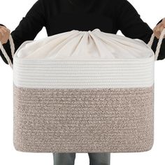 a man is holding a large white basket