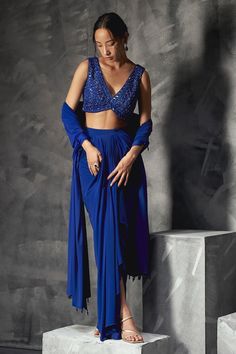 Electric blue sleeveless V neck blouse with all over sequin-cutdana-bead gardenia embroidery. Paired with a draped skirt and a glass bead tassel border embellished dupatta. - Aza Fashions Blue Sleeveless Blouse Piece, Sleeveless Blue Blouse Piece, Blue Sequined Blouse Piece For Evening, Blue Sequined Blouse For Evening, Blue Sequined Evening Blouse Piece, Sequined V-neck Sets For Party, Blue Sequined Blouse For Reception, Sleeveless Evening Blouse Piece With Sequins, Blue Sleeveless Set For Reception