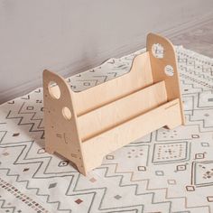 a wooden toy car sitting on top of a white and beige rug next to a wall