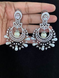 Elevate your look with these Victorian Chandbali earrings. Crafted from high-quality materials, these earrings boast an intricate design that adds an aura of elegance and sophistication to any look. Perfect for any occasion, these party wear earrings will complete your outfit with a timeless and classic finish. Luxury Formal Bridal Chandbali Sets, Luxury Silver Chandbali Bridal Sets, Luxury Chandbalis For Formal Occasions, Luxury Hallmarked Chandbali Danglers, Luxury Chandbali Danglers With Latkans, Silver Chandbalis With Intricate Design For Reception, Chandbali Chandelier Earrings With Intricate Design For Reception, Elegant Chandbali Pearl Earrings For Party, Silver Chandbalis For Reception