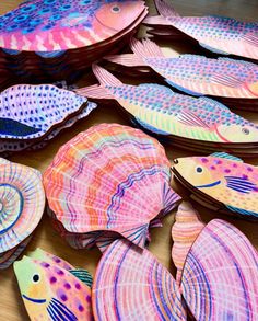 colorful paper plates with fish on them sitting on a table