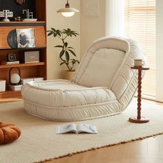 a living room filled with furniture and a book shelf next to a chair on top of a rug