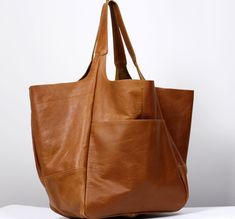 "Elegant Leather Large Carryall, Oversized leather bag, very large soft handbag, tan leather. Height: 39 cm / 15.3\" Height from top of handle to base: 68 cm / 26.8\" Handle drop: 26 cm / 10.2\" Width: 34 - 74 cm / 13.4\" - 29.1\" Depth: 28 cm / 11\" - Large, very roomy bag made of soft distressed leather. - Unlined - Inside two spacious section. - Top closure magnet for security. Add this gorgeous bag to your collection!! To return to my shop, simply click here: https://www.etsy.com/shop/Barbar Brown Leather Hobo Bag With Rolled Handles, Oversized Purse, Tan Leather Bag, Large Leather Bag, Leather Weekender Bag, Everyday Handbag, Leather Weekender, Large Leather Tote Bag, Oversized Tote Bag