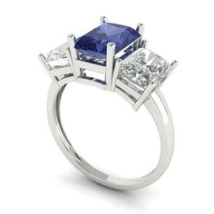 a three stone ring with two princess cut diamonds on each side and one blue sapphire in the center