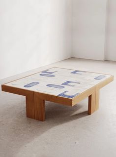 a coffee table with blue and white designs on the top, in a room that appears to be empty