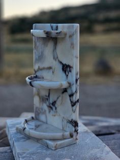 a marble fountain sitting on top of a stone slab in the middle of a field