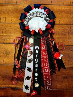 this is a wreath made out of ribbons and ribboning on a wooden floor that says welcome home coming