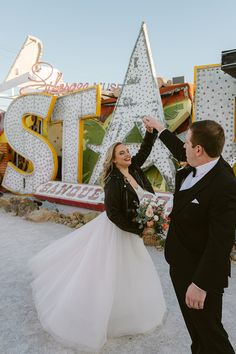 This stunning shot captures a bride in a timeless wedding dress with a fun, edgy twist - a black leather jacket! 🌟 The groom in his sharp tux initiates a playful twirl, encapsulating pure joy. Set against vibrant vintage neon signs spelling "STARDUST," this unique Las Vegas wedding scene is all about love and fun. Check out this modern, wildflower wedding theme! 🌸✨ #weddingdress #neonmuseum #vintagewedding #lasvegaswedding #wildflowerweddingtheme Vegas Bridesmaid, Wildflower Wedding Theme, Nevada Wedding, Nevada Desert, Stunning Wedding Venues, New Mexico Wedding