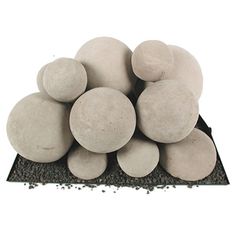 a pile of white rocks sitting on top of a black rock covered in sand and gravel