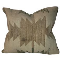 a brown and white pillow with an arrow pattern on the front, sitting on a white background