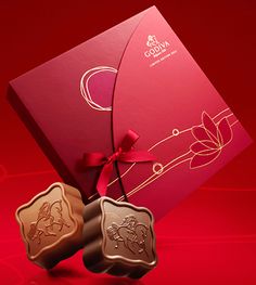 two chocolates in front of a red box