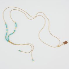 Delicate adjustable gold necklace with turquoise and gold beads and gold rectangle drop pendant. Elegant Adjustable Beaded Chain Necklace, Adjustable Beaded Necklaces With Round Beads And Chain, Adjustable Beaded Necklace With Round Beads And Chain, Adjustable Turquoise Elegant Lariat Necklace, Elegant Turquoise Beaded Lariat Necklace, Elegant Adjustable Beaded Necklace With Delicate Chain, Adjustable Beaded Chain Necklace With Round Beads, Elegant Double Strand Beaded Necklaces With Adjustable Chain, Elegant Turquoise Long Necklace With Round Beads