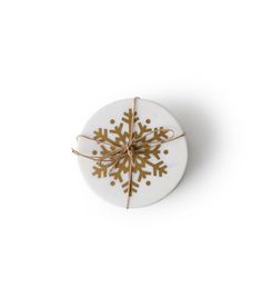 a white button with gold snowflake on it