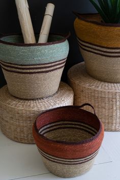 three baskets are stacked on top of each other with bamboo sticks sticking out of them