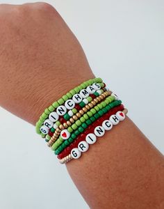 Grinch Stacking Seed Bead Bracelet,  Stink Stank Stunk, Grinch Gift, Christmas Jewelry, Holiday Bracelets, Gold, Green and Red Christmas How to find your bracelet size: Wrap a flexible tape measure, string, or ribbon around your wrist. Find your measurement and then add 1/2 an inch. This will ensure a comfortable fit for your stackable bracelets.   Bracelet care: -remove when sleeping -avoid over stretching -allow lotions to dry before wearing -remove before entering water -Made with clear stretchy elastic cord. Looking for different text on your bracelet?  Feel free to contact me with any personalization. Christmas Stretch Bracelets Ideas, Grinch Beaded Bracelet, Grinch Bracelet Ideas, Christmas Seed Bead Bracelets, Christmas Bead Bracelets, Grinch Jewelry, Christmas Bracelets Beaded, Grinch Crafts Diy, Grinch Bracelet