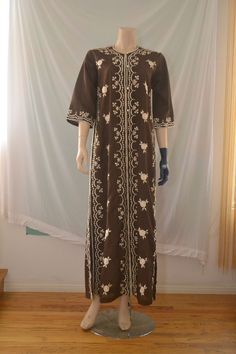 Vintage 60's/70's maxi kaftan dress with floral embroidery, side vents, bell sleeves and buttons all the way down the front. Material seems like a cotton blend. Excellent condition.  W:20" S:21" L:58" Spring Floral Embroidered Long Abaya, Spring Brown Tunic Kaftan, Traditional Maxi Length Spring Abaya, Spring Long Abaya With Floral Embroidery, Brown Tunic Kaftan For Spring, Spring Abaya With Floral Embroidery, Spring Floral Embroidered Abaya, Spring Floral Embroidered Maxi Length Abaya, Fitted Long Sleeve Kaftan With Floral Embroidery