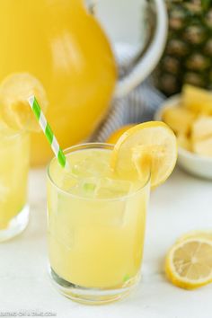 two glasses filled with lemonade next to sliced pineapple