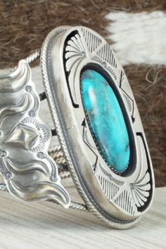 This vintage turquoise and sterling silver bracelet was made by a Navajo silversmith. The inside is signed RB and stamped sterling. Please note this is a pre-owned piece, with patina, in vintage condition.Size: 5 1/2" (will fit up to a 6 1/2" wrist)Gap: 1"Width: 2 3/8"Free shipping on all orders! We ship with USPS and always include tracking. All orders ship within a day of payment.Returns are accepted up to 30 days after you receive your order. Just send us a message. Our shop offers cash back Vintage Handmade Turquoise Sterling Silver Bracelet, Handmade Vintage Turquoise Sterling Silver Bracelet, Vintage Turquoise Concho Cuff Bracelet, Vintage Turquoise Cuff Bracelet With Concho, Western Turquoise Bracelets With Concho, Western Turquoise Bracelet With Concho, Western Style Turquoise Bracelet With Concho, Western Turquoise Bracelet With Patina, Vintage Turquoise Sterling Silver Cuff Bracelet