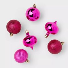 pink and gold ornaments are arranged on a white surface