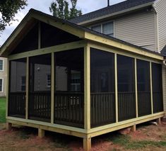 a screened in porch next to two houses