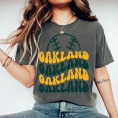 "Comfort Colors Oakland Baseball Shirt, Oakland Baseball Sweatshirt, Vintage Style Oakland Baseball shirt, Oakland Baseball fan Gift -Please check Color and Size Charts before placing the order. You can find them in the listing's photos (Depending on what device you are viewing this listing colors may vary slightly). -Returns and exchanges are accepted only if there are defects \"No Extra Costs\" We create custom t-shirts with great designs for everyone's liking. If you don't find the size or color you would like, please message us and we will be happy to  accommodate! Comfort Colors Oakland Baseball Shirt, Oakland Baseball Sweatshirt, Vintage Style Oakland Baseball shirt, Oakland Baseball fan Gift PRODUCT T-shirt Comfort Colors® 1717     Medium fabric (6.1 oz/yd² (206.8 g/m     Relaxed fi Green Fan Apparel T-shirt For Game Day, Game Day Graphic Print Top For Sports Season, Retro Gray T-shirt With Letter Print, College Fan Apparel Graphic Print Tops, College Fan Apparel Tops With Graphic Print, Fan Apparel Tops With Graphic Print, Graphic Print Tops For Game Day And Sports Season, Graphic Print Tops For Game Day, Graphic Print Top For Sports Season