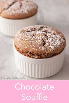 two chocolate souffles with powdered sugar on top in small white dishes