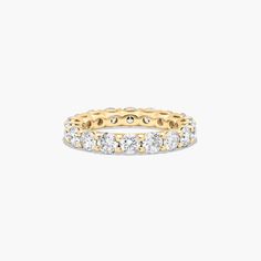 a yellow and white gold ring with five diamonds on the inside, set against a plain background