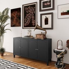 a living room with pictures on the wall and an old record player in front of it