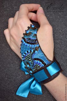 a woman's arm wearing a blue and black bracelet