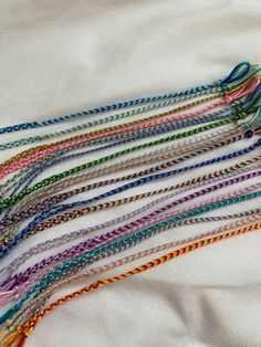 there are many different colors of braids on the white sheet that is laid out