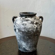 a black and white vase sitting on top of a table